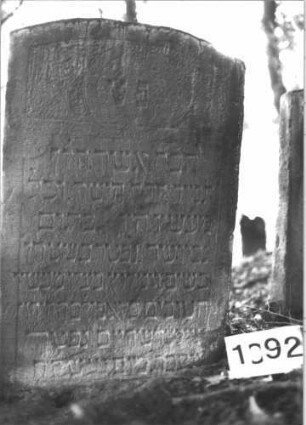 Grabstein 1092 (Index: 99899746) Material: Sandstein Zustand: unten verwittert, sonst gut erhalten, eingesunken Maße HxBxT: 102x66x11 cm Beschreibung: Stele mit Segmentbogenabschluss, im Bogenfeld Blumen, Stein ist etwas eingesunken Symbolik: Blumen: Grabstein 1092