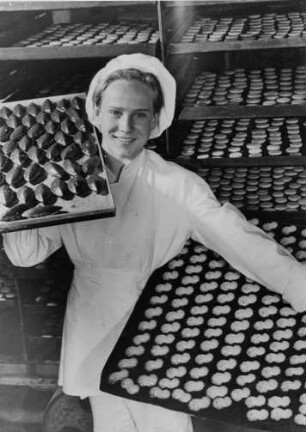 "Pro" Bäckerei. Bäcker präsentiert Backwaren auf Backblechen