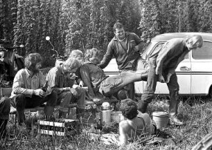 VEG (Volkseigenes Gut) Kloster Nimbschen. Hopfenpause : VEG (Volkseigenes Gut) Kloster Nimbschen. Mittagspause bei der Hopfenernte. Acht junge Erntehelfer sitzen im Grünen und machen bei Bier ihre Mittagspause. Zwei versuchen ihrem Kollegen die Stiefel auszuziehen. Die anderen beobachten das Geschehen amüsiert. Im Hintergrund steht ein Trabant P50