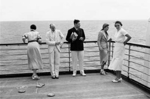 Bordleben Cap Arcona. Passagiere auf dem Oberdeck während eines Shuffleboard-Spiels