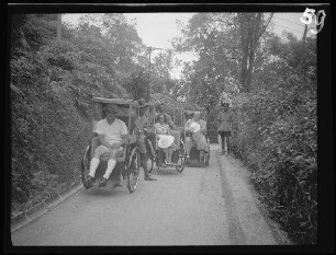 Penang (Malaysia): 2 Herren und eine Dame in Fahrradrikschas ("Rückfahrt in Rikschas von Craigs Hotel")