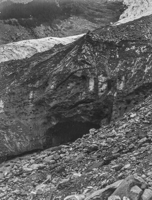 Berghang : Ein felsiger Berghang in den Alpen mit einer Höhle im Hintergrund