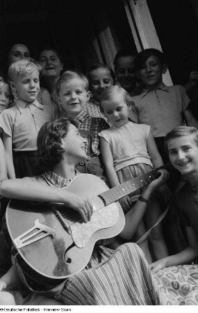Kinder beim Singen mit Betreuerin im Hauseingang der Alten Winkelmühle