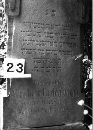 Grabstein 23 (Index: 100100633) Material: Sandstein Zustand: verwittert Maße HxBxT: 160x55x21 cm Beschreibung: Stele, Sockel, geschwungener Rundbogenabschluß , seitlich eckige Voluten: Grabstein 23 (Detailaufnahme)
