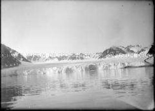 Dunkles Gebirgsband mit Schneefurchen, Gletschergestein und Fjord, Nordlandreise, Norwegen
