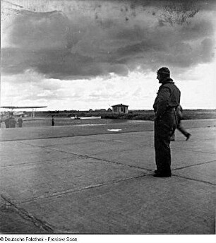 Rostock-Warnemünde. Deutsche Verkehrsfliegerschule, Zweigstelle Seefliegerschule Warnemünde. Pilot auf dem Rollfeld beobachtet ein im Hintergrund stehendes Flugzeug