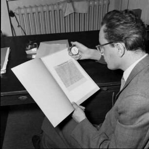 Schnell-Lesekurs. Ein Mann stoppt die Zeit, die er zum Lesen benötigt