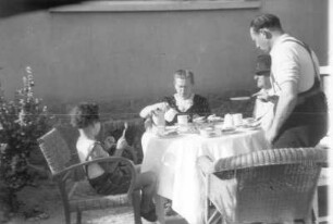 Ramon-Joachim Gerhardt mit seinem Vater Ernst Otto und zwei Verwandten beim Frühstücken im Freien