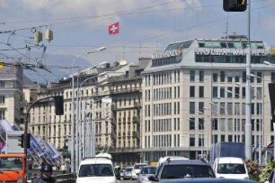 Genf - Straßenverkehr : Blick über die Brücke auf die Geschäftshäuser am rechten Rhôneufer bei dichtem Nachmittagsverkehr. Aufgenommen in Genf am 21. Mai 2010