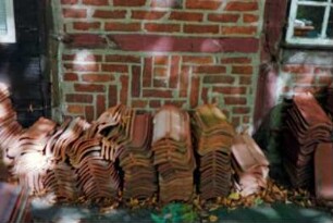 Sühlen: ehemalige Müllerkate: Fachwerkbau: Sanierung: Giebelseite, Detailaufnahme: vor Hauswand Stapel mit Dachziegeln