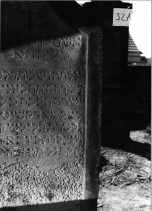 Grabstein 32 (Index: 99797933) Material: Sandstein, weiß Zustand: stark verwittert Maße HxBxT: 129x62x11 cm Beschreibung: Stele, geschweifter Abschluß: Grabstein 32A