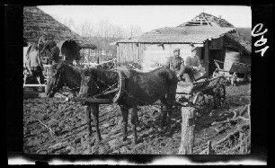 bei Wirballen (?) (=Virbalis, Litauen): 2 Soldaten auf dem Wagenkarren eines Zweispänners in einem morastigen landwirtschaftlichen Innenhof ("Fahrzeug")