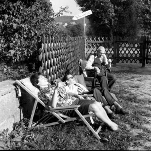 Ferien vom Ich. Drei Feriengäste im Garten ruhend
