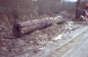 Moorweg: bei Durchlass Alte Alster: Fundstück Rohrleitung aus Holz, nach Bergung: Gesamtansicht, vorne Querschnitt: hinten rechts Bagger [angeschnitten], Warnbake
