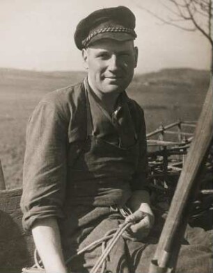 Portrait eines jungen Handwerkers aus der Großstadt der den Bauern bei der Landarbeit hilft