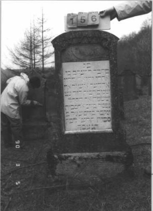 Grabstein 156 (Index: 99608840) Material: Sandstein Zustand: gut Maße HxBxT: 122x52x20 cm Beschreibung: Stele, getreppter Sockel, Segmentbogen mit Rundbogenfries, Schrifttafel Symbolik: Schofar Besonderheit: kulturhistorisch wertvoll / hist.-wiss. Gründe (Gemeindestellung): Grabstein 156