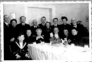 Gruppenbildnis vor einer Festtafel (wohl auf einer Familienfeier)
