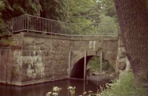 Mühlenredder: Brücke über Abfluss des Schlossgrabens in Aue: Seitenansicht von Süden: vor Brückenbogen senkrechte Eisenträger: oben Geländer
