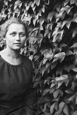 Bildnis einer Frau vor einer Hecke