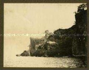 Einbaum mit Askaris an einer Steilküste
