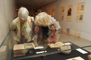 SLUB, Ausstellung "Gespräche mit der Erde. Geowissenschaften in Sachsen" : Ausstellungseröffnung am 14. Oktober 2014 im Vortragssaal. Gäste an einer Ausstellungsvitrine im Buchmuseum