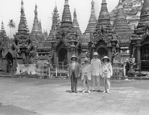 Rangun, Birma. Gruppenbild mit vier Touristen der Hapag vor Nebentürmen der Shwedagon-Pagode