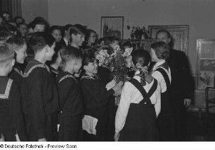 Pioniere überreichen einem Mitglied des Thomanerchors Blumen