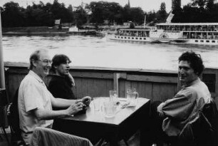 Der Verleger Hansgert Lambers, der Buchgestalter Stefan Wendel und der Fotograf Werner Lieberknecht im Biergarten am "Elbehotel", im Hintergrund Personen-Seitenraddampfer "Dresden"
