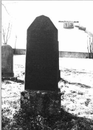 Grabstein 13 (Index: 100116093) Material: Granit, poliert Zustand: gut Maße HxBxT: 170x51x18 cm Beschreibung: aufgesockelte Stele mit abgeflachtem giebelartigem Abschluß: Grabstein 13