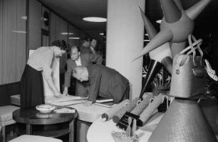 Auf der Leipziger Herbstmesse 1955 am Stand vom VEB Vogtländische Wachstuchfabrik Treuen in Specks Hof auf der Leipziger Herbstmesse 1955 ausgetellte Taschen aus Kunstleder sowie Ballen für die Polsterung