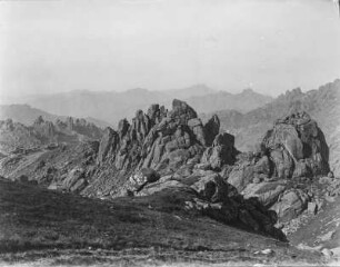 Felsformation : Blick auf einzeln stehende Granitfelsen und dahinter liegende Bergketten