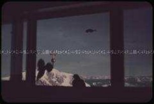 Blick auf das Gipfelkreuz auf der Zugspitze durch das Fenster der Gipfelstation