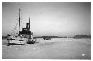 Schleppdampfer "Putbus", vor Rügen in Küstennähe vor Anker liegend, umgeben von geschlossener Eisdecke
