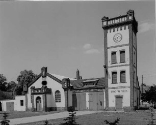 Tauer, Hauptstraße 106. Feuerwache. Uhrenturm (1896), Feuerwehrhaus (1896) und Turnhallenanbau (1913). Straßenansicht