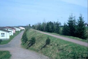 ehemaliger Bahndamm der "Laura" am Ortsrand; links einzelne Bungalows