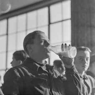 Borgward-Lehrling trinkt Milch aus einer Flasche