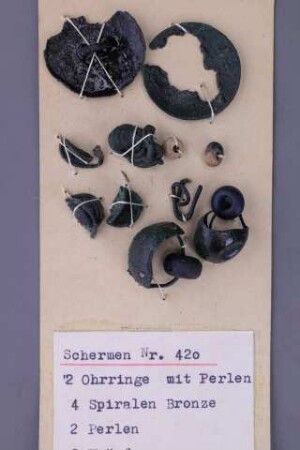 Segelohrringe mit blauer Glasperle, Bronzespiralen und Bronzeknöpfe