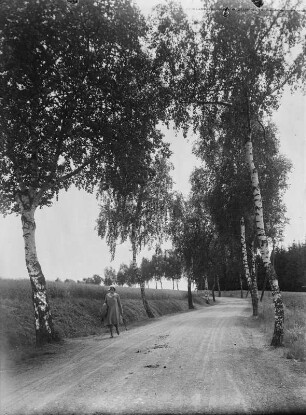 Spaziergängerin auf einer unbefestigten Landstraße