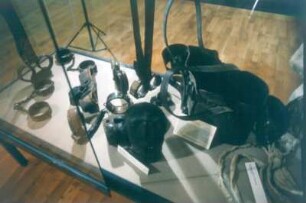 Haina. Psychiatriemuseum. Vitrine mit "Beruhigungsinstrumenten" aus dem 19. Jahrhundert, darunter Zwangsjacke, Handschellen, Fußschellen