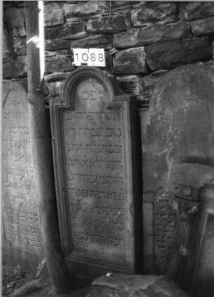 Grabstein 1088 (Index: 99630591) Material: Sandstein Zustand: leicht verwittert Maße HxBxT: 148x58x12 cm Beschreibung: Stele mit eingezogenem Rundbogenabschluß, Schriftfeld eingetieft: Grabstein 1088