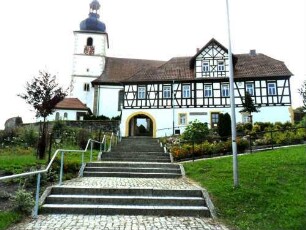 Ansicht im Norden mit Kirche über Kirchhofmauer sowie (verändertem) Torhaus und anschließendem Gaden (zum Wohnhaus umgebaut)