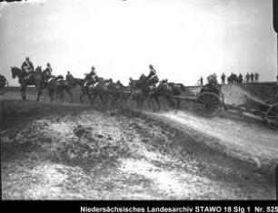 Geländeübung des Feld-Artillerie-Regiments Nr. 46 Enthält: Platte 14, Soldaten auf einer mit Pferden bespannten Geschützlafette fahren einen Weg hinauf, im Hintergrund: Zuschauer