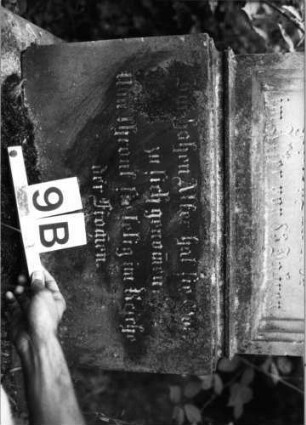 Grabstein 9 (Index: 99804478) Material: Sandstein Zustand: gebroch/repariert/Textverl/verwitt Maße HxBxT: 167x56x23 cm Beschreibung: Stele, getreppter Sockel, getrppter Abschluß, Schrift mit Maßwerk: Grabstein 9B