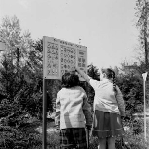 Zwei Mädchen beim Betrachten einer Tafel mit Verkehrszeichen