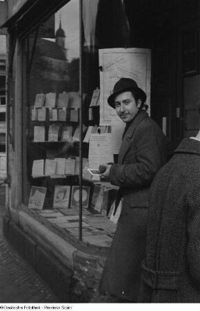 Junger Mann (Rolf) an einer Buchhandlung