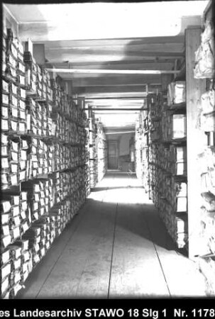 Braunschweigisches Landeshauptarchiv/Niedersächsisches Staatsarchiv in der Alten Kanzlei, Wolfenbüttel [um 1950] Enthält: Gang durch ein Magazingeschoss, links und rechts Regale mit Aktenpaketen