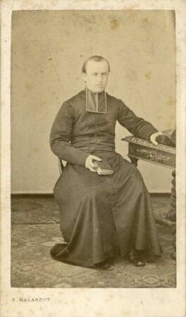 Fotografie eines sitzenden Geistlichen