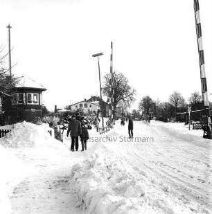 Bahnübergang Ratzeburger Straße: rechts und links Signalanlagen: links Streckenpostenhaus: in der Mitte auf Fußweg und auf Straße Fußgänger: hinten Mitte Wohnhäuser: Winter