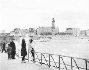 Winterurlauber an der zugefrorenen Küste der Ostsee in Warnemünde