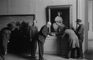 Eröffnung der Dauerausstellung in der Alten Nationalgalerie : Ludwig Justi, Direktor der Nationalgalerie, mit Aufbauhelfern beim Aufhängen des Gemäldes "Bildnis der Sängerin Jenny Lind" von Eduard Magnus